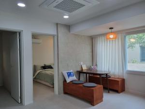 a bedroom with a bed and a table and a desk at Calmers in Pohang