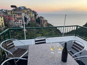 einen Tisch mit zwei Gläsern Wein auf dem Balkon in der Unterkunft Appartamento Isola - In the center with Terrace - sea view & AC in Corniglia