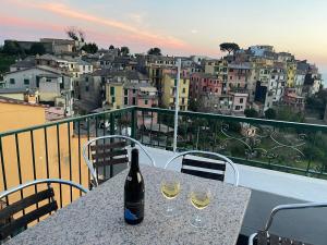 una botella de vino sentada en una mesa con dos copas en Appartamento Isola - In the center with Terrace - sea view & AC, en Corniglia