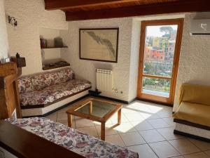 ein Wohnzimmer mit einem Sofa und einem Couchtisch in der Unterkunft Appartamento Isola - In the center with Terrace - sea view & AC in Corniglia