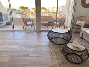 a living room with two tables and a balcony at Marina appartement sur l’eau in Le Grau-du-Roi
