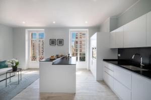 uma cozinha com armários brancos e bancadas pretas em Le COQ Charlene - Monaco à 50m - New em Beausoleil