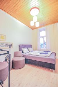 1 dormitorio con 1 cama con muebles de color púrpura y ventana en Comfortable Accommodations in the Alterlaa Area LV3 en Viena