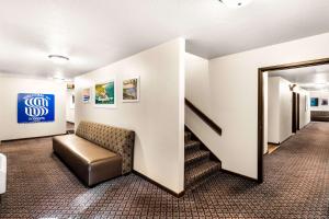 a waiting room with a chair and a stair case at Americas Best Value Inn Marquette in Marquette