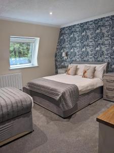 ein Schlafzimmer mit einem großen Bett und einem Fenster in der Unterkunft Loch Ness Drumnadrochit Hotel in Drumnadrochit