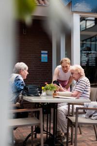 un grupo de personas sentadas en una mesa en Hotel Restaurant BEAU, en Bergeijk