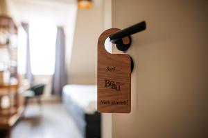 a wooden door handle with the words justbeginmet stomach at Hotel Restaurant BEAU in Bergeijk