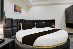 um quarto com uma cama grande e uma cabeceira preta em OYO Hotel Sunset em Ahmedabad
