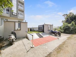 a motorcycle parked next to a building with a red carpet at The Nines Hotel & Restro in Kālādhūngi