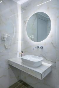 a white bathroom with a sink and a mirror at KOSTA MARIA in Paleros