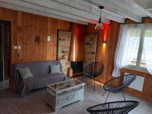 - un salon avec un canapé, des chaises et une cheminée dans l'établissement Gîte de pleine nature en dordogne, à Saint-Mesmin