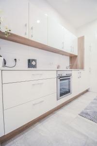 cocina con armarios blancos y fogones en Comfortable Accommodations in the Alterlaa Area LV3 en Viena