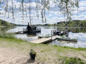 un molo con due barche su un lago di Newly built guest house located in Vimmerby a Vimmerby