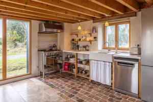 a kitchen with stainless steel appliances and windows at Gîtes de Lézinadou - 4 pers - Plomeur La Torche. in Plomeur +4 photos