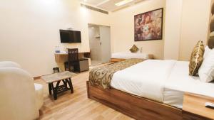 a hotel room with a bed and a television at Hotel Sallow Royal Suites in Amritsar