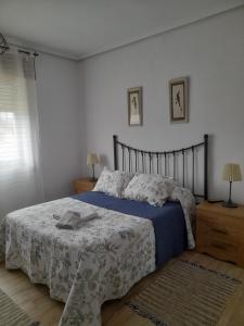 a bedroom with a bed with a blue and white blanket at Casa Pili in Rivero