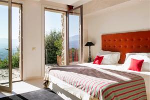 a bedroom with a large bed with a red headboard at Castello di Velona Resort, Thermal SPA & Winery in Montalcino