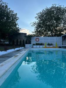 una piscina de agua azul en un patio en La Căsuțe en Silvaşu de Jos