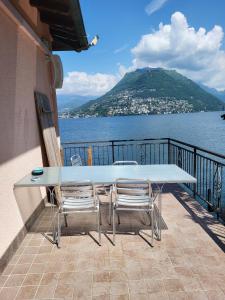 a table and chairs on a balcony with a view of the water at Dreamapartment 4 Roomlake in Lugano