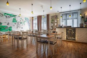 um restaurante com mesas e cadeiras de madeira e um mural em Bohem Prague Hotel em Praga