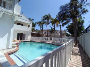 una piscina en el balcón de una casa con palmeras en The Rose on Fairway, en Durban