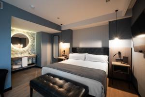 una habitación de hotel con una cama grande y un sofá en Catalonia Atenas, en Barcelona 33 fotos más