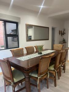 a dining room table with chairs and a mirror at 2 Bedroom Apartment in Waverley, Bloemfontein in Bloemfontein