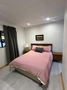 a bedroom with a large bed with a pink blanket at 2 Bedroom Apartment in Waverley, Bloemfontein in Bloemfontein