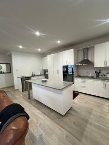 a large kitchen with white cabinets and a counter top at 2 Bedroom Apartment in Waverley, Bloemfontein in Bloemfontein