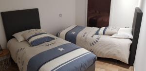two beds sitting next to each other in a room at Chez Marcel Gite PMR in La Marne +33 photos