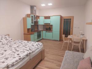 a bedroom with a bed and a kitchen with a table at Apartmán IRIS Poděbrady in Poděbrady