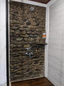 uma parede de pedra com um lavatório no corredor em Kengbari Retreat em Gangtok