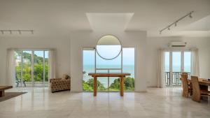 バトゥ・フェリンギにあるPanoramic Seaview Holiday Home - Batu Ferringhiのリビングルーム(テーブル、鏡付)