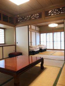 Zimmer mit 2 Betten und einem Holztisch in der Unterkunft Satoyama no Yado Kei-House - Vacation STAY 55796v in Shikokuchuo