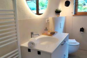 a bathroom with a sink and a mirror at Homely Stay Velosoph Quartier - Familienfreundliches Ferienhaus mit 3 Schlafzimmern, 300m zur Ski-Piste, E-Auto Ladestation in Bayrischzell +47 photos