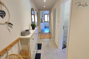 a hallway of a home with white counters and a mirror at Homely Stay Velosoph Quartier in Bayrischzell