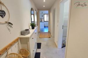 a hallway of a home with white counters and a mirror at Homely Stay Velosoph Quartier - Familienfreundliches Ferienhaus mit 3 Schlafzimmern, 300m zur Ski-Piste, E-Auto Ladestation in Bayrischzell