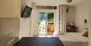 ベナルマデナにあるPretty Studio with a sea view Agataのベッド2台付きの部屋、パティオへのドア