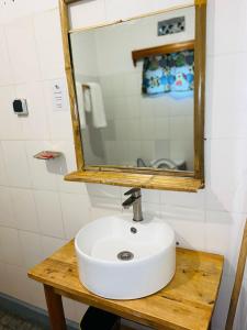a bathroom with a white sink and a mirror at Isange Paradise Resort in Ruhengeri