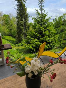 een vaas met bloemen op een tafel met stoelen bij House Blanka,kuća za odmor in Skrad