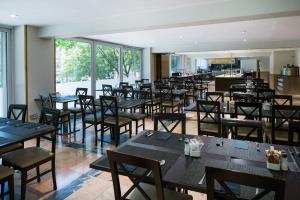 a dining room with tables and chairs and windows at Catalonia Atenas in Barcelona