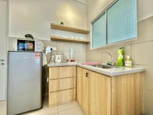 a kitchen with a refrigerator and a sink at Amber Cove Melaka in Melaka