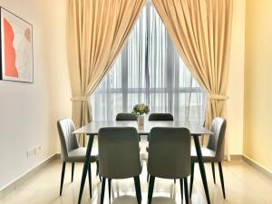 a dining room with a table and chairs and a window at Amber Cove Melaka in Melaka