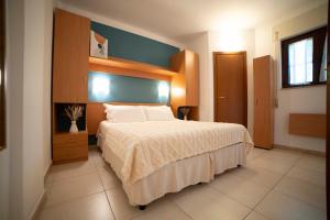 a bedroom with a large bed with a blue wall at Villaggio San Matteo Resort in Mattinata