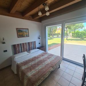 a bedroom with a bed and a large sliding glass door at Agriturismo L'Albara - Wines, Pool & SPA in Villaganzerla +95 photos