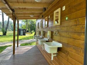 a row of sinks on a wooden wall at ECO River Camp - Pitches in Radovljica