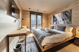 Luxury Ski Chalet Andorra في سولديو: غرفة نوم بسرير كبير ومكتب