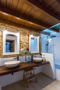 two sinks in a bathroom with two mirrors at Hort den Pilot in Sant Rafael de Sa Creu