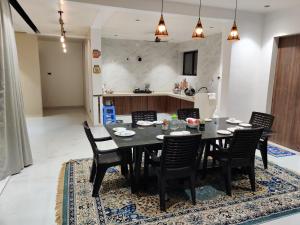 a dining room with a black table and chairs at The Marigold Villa in Pune