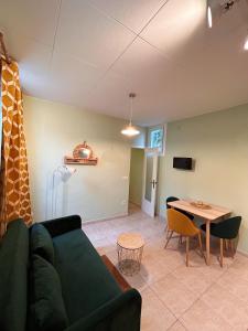 een woonkamer met een groene bank en een tafel bij Central Market Apartment in Calella